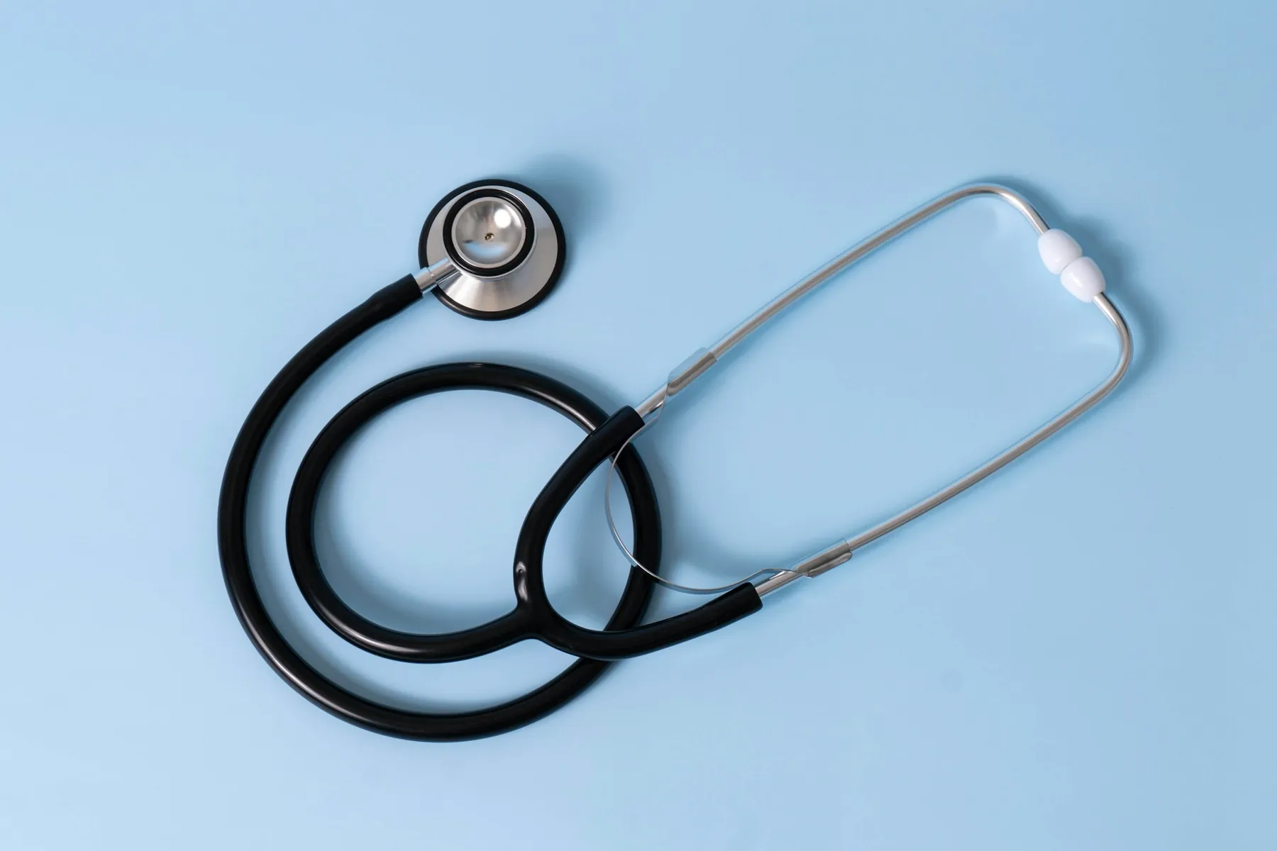 A stethoscope resting on a soft blue surface