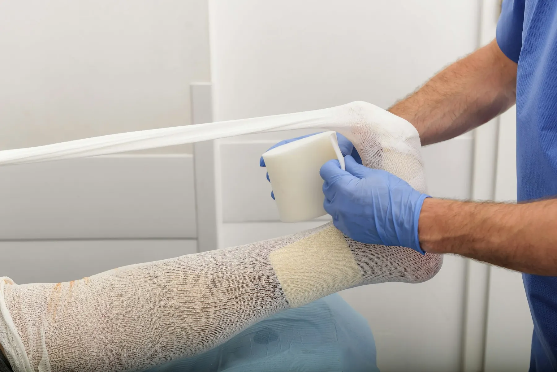 Gloved hands carefully dressing a wound